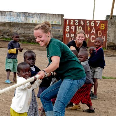 Projects Abroad volunteers work with children in Ghana. Childcare volunteer plays a game with children during her work experience in Ghana.